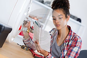 Woman reading instructions before reparing boiler