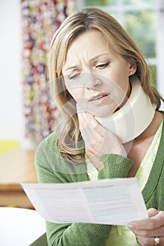 Woman Reading Letter After Receiving Neck Injury