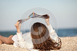 Woman reading magazine on beach