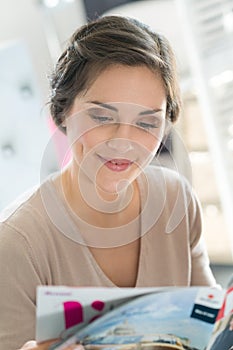 woman reading magazine in cafe photo