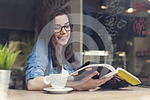 Žena čtení časopis v kavárna 