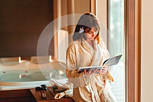 Woman reading magazine while waiting for massage at spa center