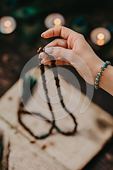 Woman reading mantras or prayers from ancient Holy Book, counts malas strands of wooden beads used during meditations