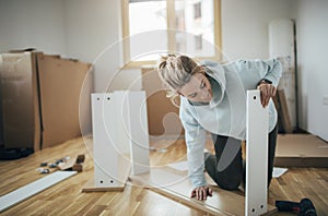 Woman reading manual for assembling furniture