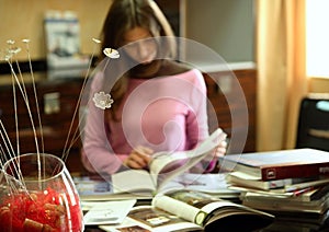 Woman reading many books indoors
