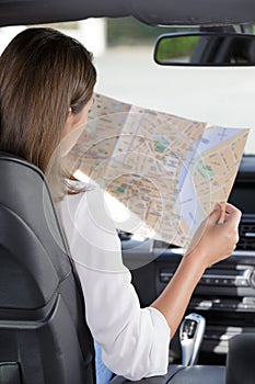 woman reading map in car