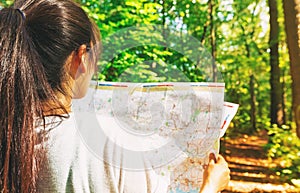 Woman in reading a map in the forest