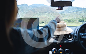 A woman reading a map and pointing finger to the right direction while riding in a car