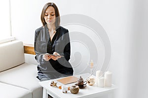 Woman is reading metaphorical cards on the table in home office.