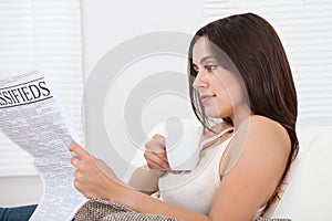 Woman Reading Newspaper At Home