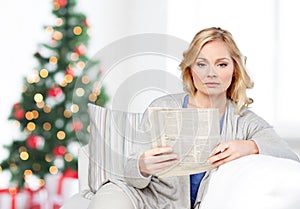 Woman reading newspaper at home