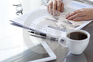 Woman reading newspaper on table