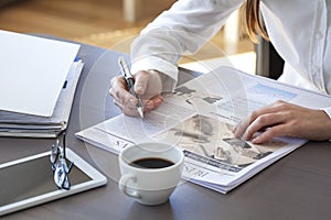 Woman reading newspaper on table