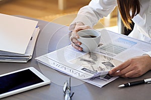 Woman reading newspaper on table