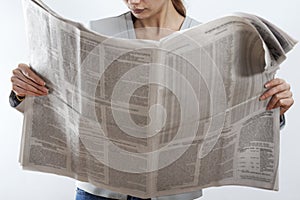 Woman reading newspaper on white background