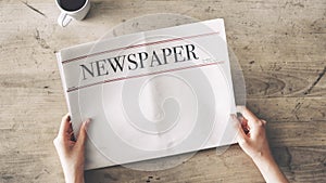 Woman reading newspaper on wooden background