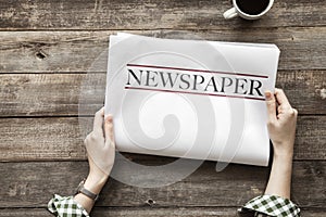 Woman reading newspaper on wooden background