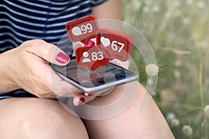woman reading notifications on smartphone on the grass