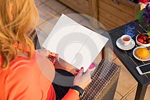 Woman reading promotional booklet, empty mockup for your own design.