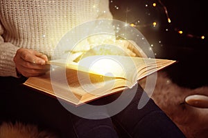 Woman reading shiny magic book, closeup