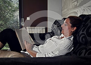 Woman reading on the sofa quietly photo