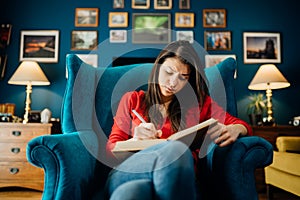 Woman reading/studying a foreign language from a book at home.Highlighting/Underlining difficult literature.Concentration problems photo