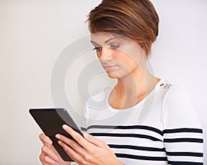 Woman, reading and tablet on a white background for online information, streaming and search by a wall or at home. Young