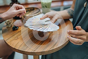 Woman is reading Tarot cards with a cusomer in cafe