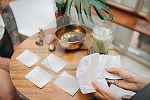 Woman is reading Tarot cards with a cusomer in cafe