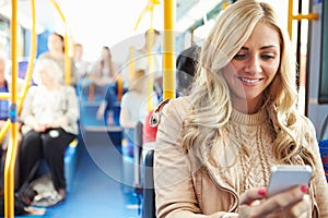 Woman Reading Text Message On Bus photo