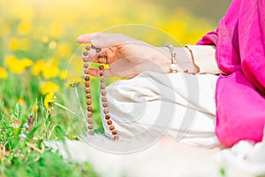 Woman reads the yoga mantra during practice with the mala