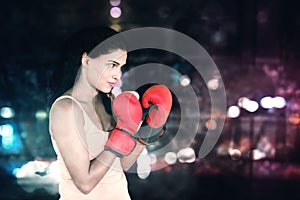 Woman ready to fight on blurred lights background