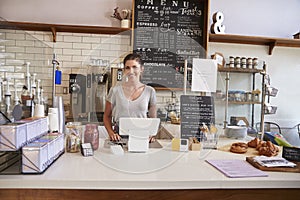 Woman ready to serve behind the counter at a coffee shop