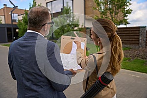 Woman real estate agent shows blueprint of house to client