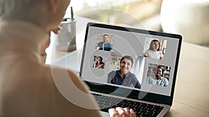 Over woman shoulder laptop with five diverse people on screen photo