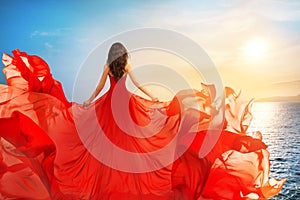 Woman Rear view in Red Flying Dress Fluttering on Wind, Girl in Waving Gown on Sea photo