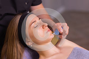 Woman receives facial cupping massage facial rejuvenation at acupuncture wellness spa.