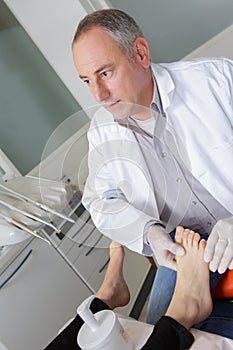 Woman receives foot examination from gloved podiatrist