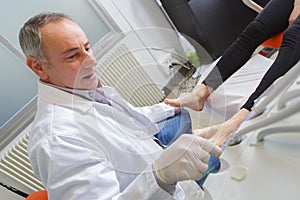 Woman receives foot examination from gloved podiatrist photo