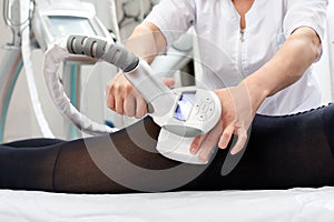 Woman receives LPG massage to remove cellulite from her body, for lifting legs. Concept beauty therapy in spa salon.