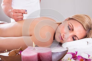 Woman receiving an acupuncture therapy