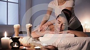 Woman receiving back massage, enjoying evening in spa