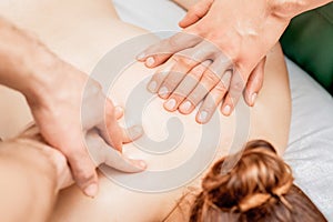 Woman receiving back massage with four hands