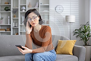 Woman receiving bad news and feeling confused at home