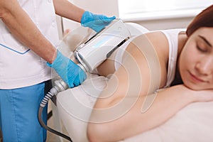 Woman receiving body cosmetology treatment at beauty clinic