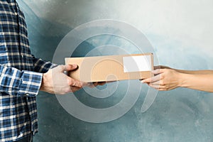 Woman receiving boxes from delivery man against blue background