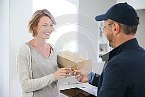 Woman receiving delivery man with package