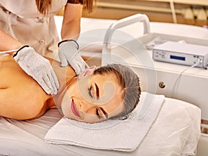 Woman receiving electricity gloves massage at beauty salon.