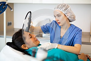 Woman receiving face ultrasound lifting procedure