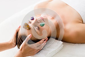 Woman receiving facial stone massage